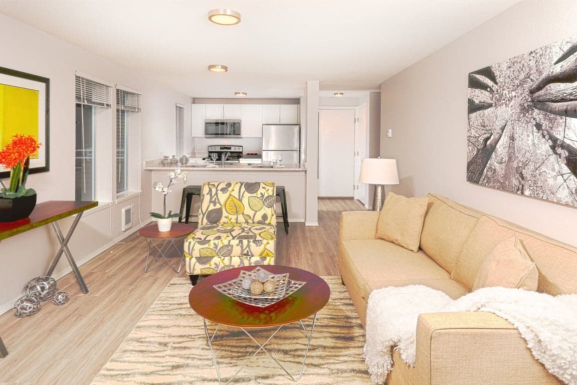 Westwood Court Seattle apartment: bright living room with large windows, sofa, and neutral decor.
